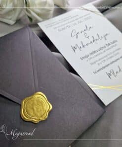 Ova pozivnica se sastoji od bijelog papira sa ukrasnim detaljima od zlatotiska i prateće crne koverte sa zlatnom nalepnicom koja imitira voštani pečat.