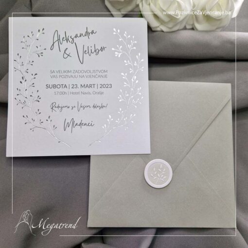 Prikaz pozivnice za vjenčanje 10364 koja se sastoji od bijelog kvadratnog papira sa srebrotiskom i prateće sive koverte sa nalepnicom.