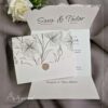 Prikaz pozivnice za vjenčanje koja jenapravljena od bijelog papira sa dva mjesta za presavijanje papira. Pozivnica sadrži dekorativni zaltotisak i crne cvjetne ilustracije.